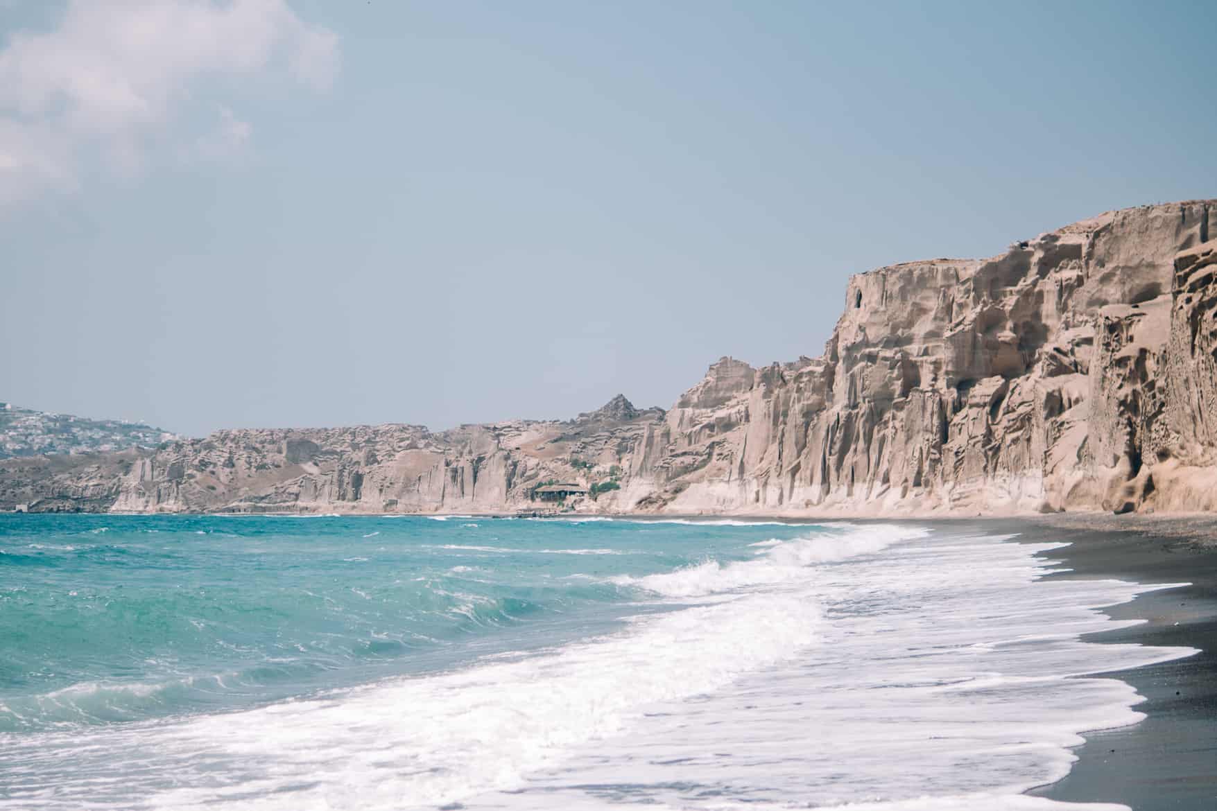 Santorini Travel Guide: Klares Wasser vor schroffen Felsen am Vlychada Beach